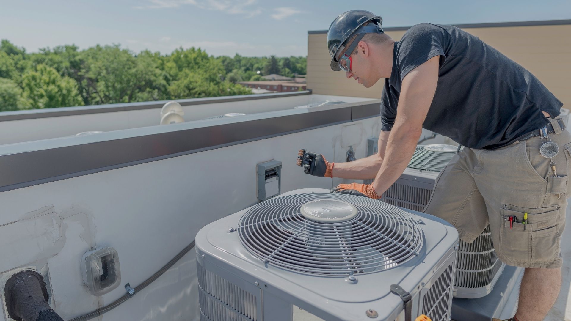 commercial AC tech on roof with HVAC